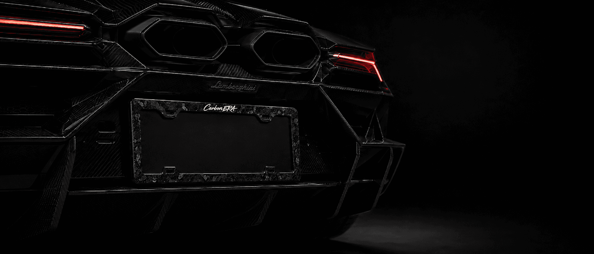 Carbon-fiber license plate frame mounted on a black performance car